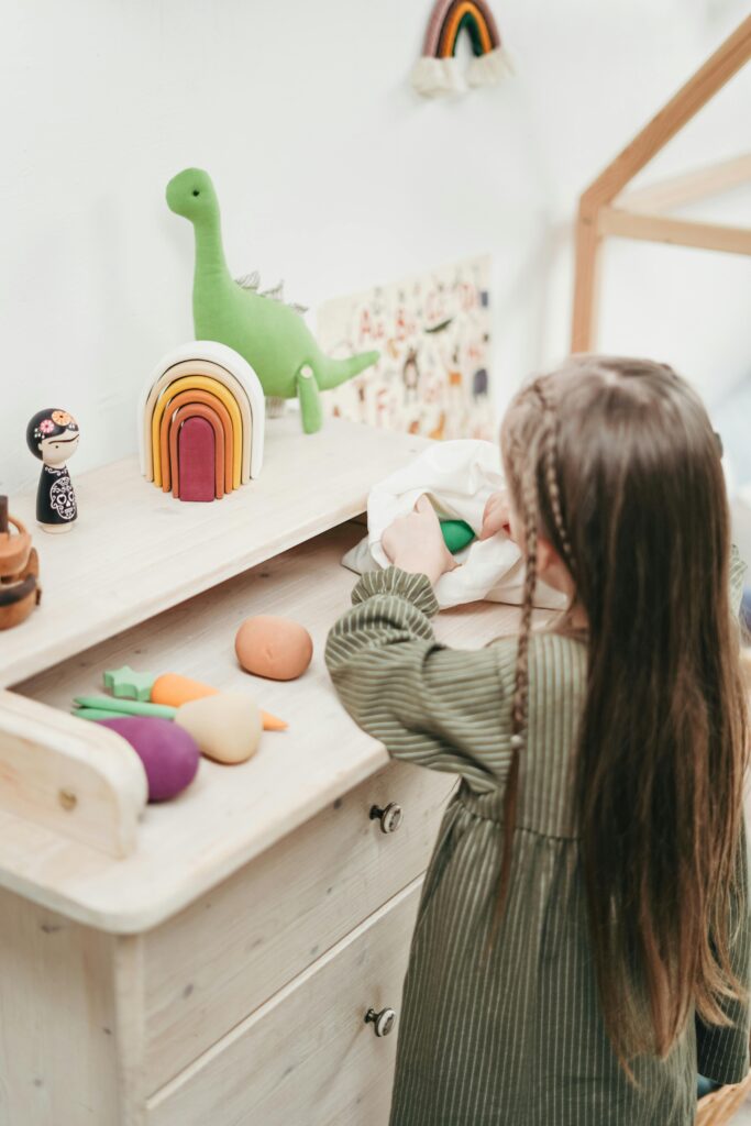 Girl enjoys playtime with wooden toys in cozy playroom setting.